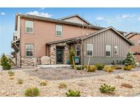 Charming two-story home featuring a stone-accented entrance and drought-resistant landscaping for easy maintenance at 8437 Mount Kataka Loop, Littleton, CO 80125