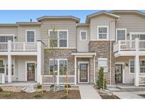 Attractive townhome showcasing stone accents, covered porch and landscaped front yard at 8887 San Antonio St, Littleton, CO 80125
