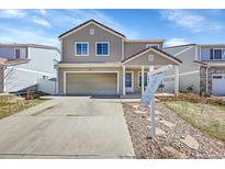Charming two-story home features a well-maintained lawn, inviting entrance, and attached two-car garage at 5214 Perth Ct, Denver, CO 80249