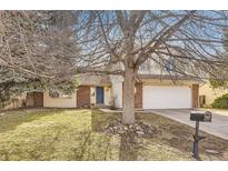 Two-story home with beige siding, brick accents, and an attached two-car garage at 1348 E Jamison Ave, Centennial, CO 80122