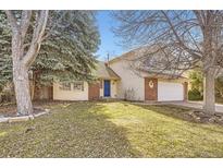 Charming two-story home with a well-maintained lawn, mature trees, and a bright blue front door at 1348 E Jamison Ave, Centennial, CO 80122