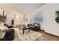 Bright living room with hardwood floors, large windows, and comfortable seating arrangement at 1348 E Jamison Ave, Centennial, CO 80122
