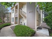Attractive two-story condo featuring well-manicured landscaping, inviting entryway, and visible unit number at 8775 W Berry Ave # 203, Littleton, CO 80123