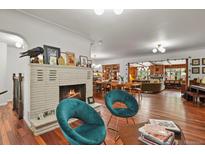 Spacious living room featuring a stone fireplace, hardwood floors, and stylish decor at 4040 Cody St, Wheat Ridge, CO 80033