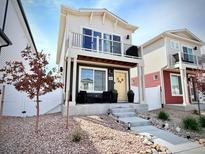 Charming two-story home with a balcony, landscaped front yard, and inviting entryway on a sunny day at 5027 N Walden Way, Denver, CO 80249