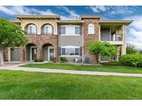 Multi-level townhouse with stone accents, manicured lawn, and inviting curb appeal at 6222 Kilmer Loop # 103, Golden, CO 80403
