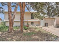 Charming home featuring a well-manicured lawn, mature trees, and a welcoming facade at 15691 E Atlantic Cir, Aurora, CO 80013