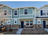 Inviting two-story townhouse with stone accents, blue siding, and well-maintained landscaping at 5760 Ceylon St, Denver, CO 80249