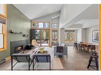 Bright, open-concept living room features a modern fireplace, high ceilings, and floor to ceiling windows at 293 Settlers Dr, Breckenridge, CO 80424