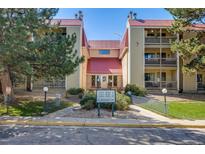 Inviting exterior view of a condo building with a red roof and well-maintained landscaping at 14852 E Kentucky Dr # 928, Aurora, CO 80012