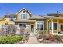 Charming townhome featuring a stone facade, covered porch, and well-maintained landscaping at 720 Reid Pl, Castle Rock, CO 80108