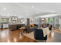 Bright, open-concept living room features hardwood floors and modern furnishings at 2717 S Langley Ct, Denver, CO 80210
