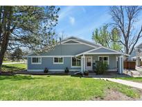 Charming single-story home with blue siding, manicured lawn, and front yard landscaping at 2557 S Dover St # 12, Lakewood, CO 80227