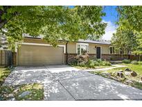 Charming one story house with a two-car garage, brick accents and mature trees in the front yard at 14797 E Temple Dr, Aurora, CO 80015