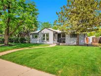 Charming single-story home features a well-maintained lawn, sidewalk, and mature shade trees at 5152 Bryant St, Denver, CO 80221