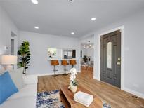 Bright living room featuring hardwood floors and a view to the dining room at 5152 Bryant St, Denver, CO 80221