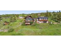 Stunning multi-level home on a hill with balconies and lush greenery at 393 Dixon Rd, Boulder, CO 80302
