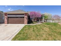 Charming home featuring a well-maintained lawn, beautiful landscaping, and a cozy covered porch at 13668 Plaster Cir, Broomfield, CO 80023