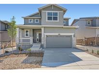 Charming two-story home featuring a covered porch, two-car garage, and appealing gray siding at 10984 Snowdon St, Parker, CO 80134