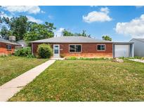 Charming brick home with a well-maintained lawn and attached garage at 9320 Fir Dr, Thornton, CO 80229