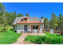 Charming home featuring a copper roof, gray door, and wooden deck perfect for enjoying the outdoors at 9092 Gray Ln, Conifer, CO 80433