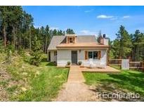 Charming home with a well-manicured lawn and a welcoming front porch at 9092 Gray Ln, Conifer, CO 80433
