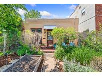 Charming home featuring a well-maintained front yard with garden beds and a cozy entrance at 34 W Maple Ave, Denver, CO 80223