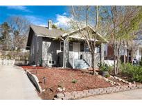 Charming two-story home with a well-manicured yard featuring mature trees, a concrete driveway, and a welcoming covered porch at 2754 S Sherman St, Englewood, CO 80113