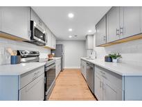 Modern kitchen with stainless steel appliances, white subway tile backsplash, and gray cabinetry at 1344 Sable Blvd, Aurora, CO 80011