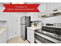 The kitchen features stainless steel appliances, white cabinets, and light countertops at 14751 E Tennessee Dr # 225, Aurora, CO 80012