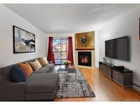 Cozy living room featuring a fireplace, balcony access, stylish decor, and comfortable seating at 14751 E Tennessee Dr # 225, Aurora, CO 80012