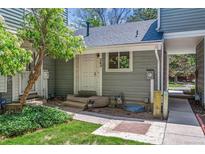 Charming front entrance of home with gray siding, a white door, and a small, well-maintained yard at 262 S Nome St, Aurora, CO 80012