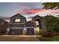 Charming two-story home featuring a well-manicured lawn, two-car garage, and beautiful flowering bushes at 11545 E 119Th Ave, Commerce City, CO 80640