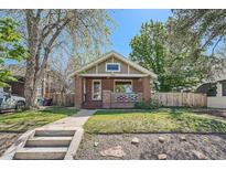 Charming brick bungalow with a welcoming front porch and well-maintained lawn at 2836 Cherry St, Denver, CO 80207