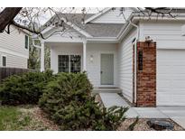 Inviting front entrance with brick accents, manicured landscaping, and a light green door at 4264 Thorndyke Pl, Broomfield, CO 80020