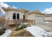 Charming exterior with stone accents, well-maintained landscaping, and attached garage at 2601 S Kipling Ct, Lakewood, CO 80227