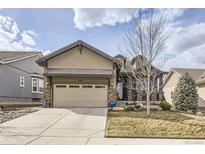 Charming home boasts a well-manicured lawn, a spacious two-car garage, and a welcoming stone-accented entrance at 15831 Lavender Pl, Broomfield, CO 80023