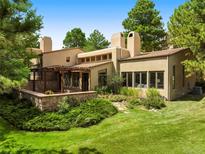 Stunning home featuring stucco and stone accents, lush landscaping, and a private pergola-covered patio at 2107 Ridge Plaza Dr, Castle Rock, CO 80108