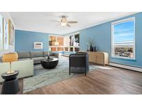 Bright living room with large windows, hardwood floors, ceiling fan, and comfortable furniture at 320 S Ames St # 5, Lakewood, CO 80226