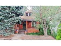 Charming brick home with lush trees, inviting curb appeal, and quaint front entrance at 588 S Grant St, Denver, CO 80209