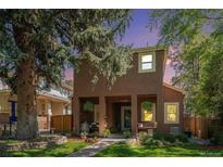 Charming two-story home with a cozy front porch and a beautifully landscaped front yard at 1250 Oneida St, Denver, CO 80220