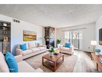 Inviting living room features a stone fireplace and sliding doors to the outside at 922 S Walden Street St # 103, Aurora, CO 80017