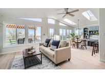 Bright living room with large windows, vaulted ceilings, and an open concept design leading to an outdoor patio at 5855 Rustic Knolls Dr, Boulder, CO 80301