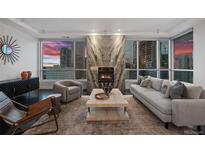 Contemporary living room with fireplace, floor-to-ceiling windows and amazing city views at 2001 Lincoln St # 1811, Denver, CO 80202