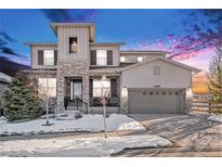 Two-story house with stone accents and a three-car garage at 11898 Discovery Cir, Parker, CO 80138