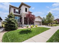 Charming two-story home featuring stone accents, a well-manicured lawn, and an attached two-car garage at 11898 Discovery Cir, Parker, CO 80138