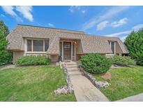Charming home featuring a unique roofline, well-manicured lawn, and inviting stone walkway leading to the front door at 31 Irene Ct, Broomfield, CO 80020