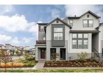 Attractive townhome with a charming covered front porch and professional landscaping at 6303 Elmira St, Denver, CO 80238