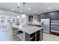 Modern kitchen with large granite island, stainless steel appliances, dark wood cabinets, and pendant lighting at 16021 Williams Pl, Broomfield, CO 80023