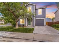 Charming home featuring a two-story design, attached garage, well-kept lawn, and healthy mature shade tree at 5320 E 100Th Dr, Thornton, CO 80229